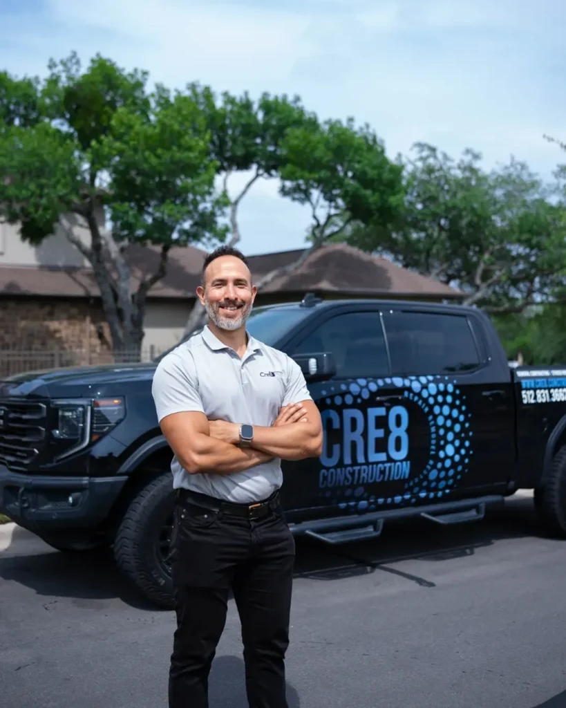 Andre Luna, owner of Cre8 Construction, standing with a company truck