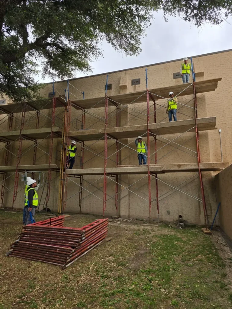 Crew on scaffold at an institutional building wall